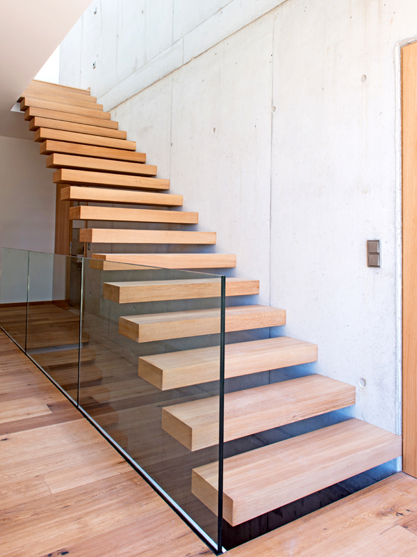 Eine Freitragende Treppe im Holz design mit edlem Glasgeländer.
